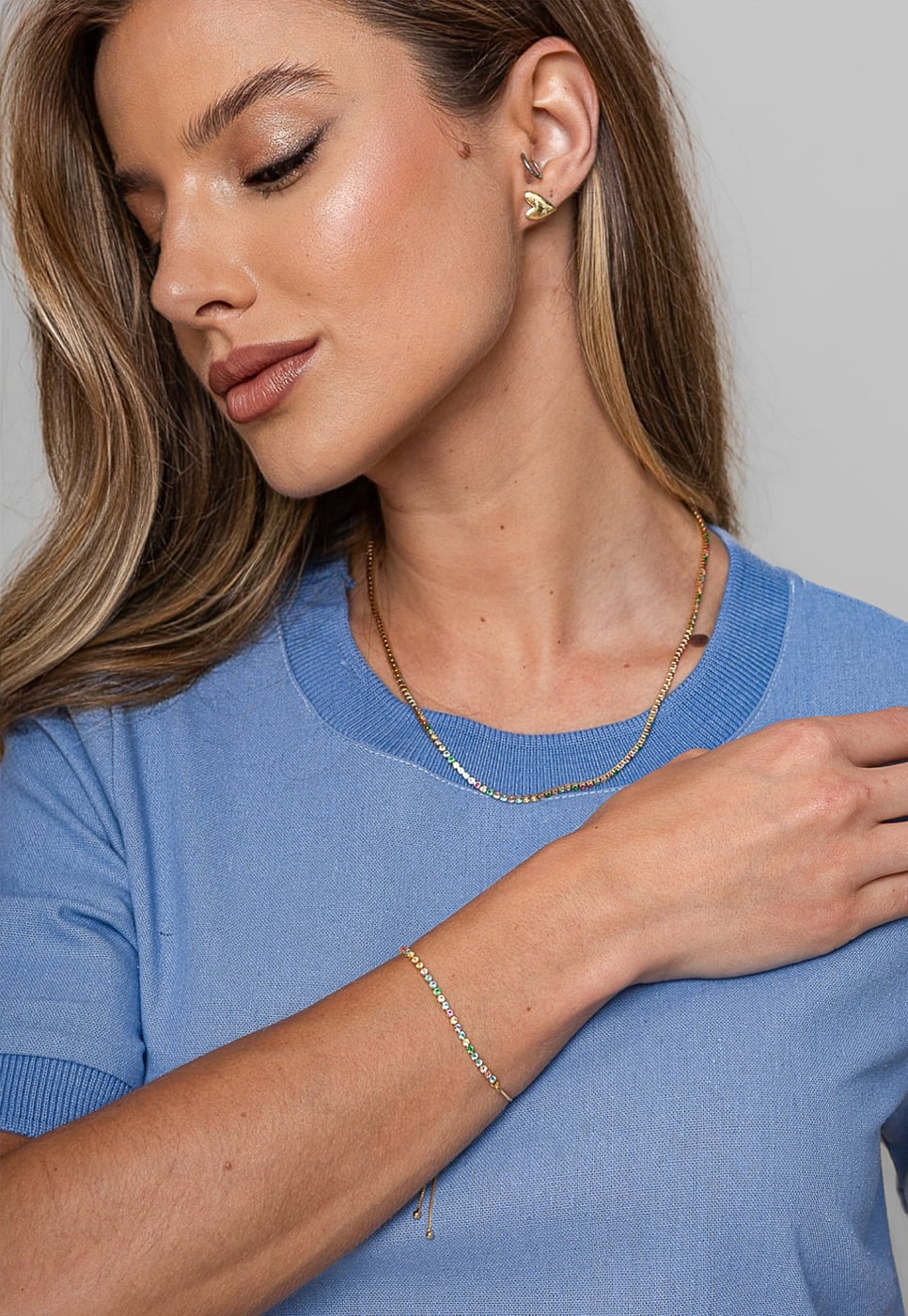 Pulseira riviera colorida sendo usada no pulso por modelo
