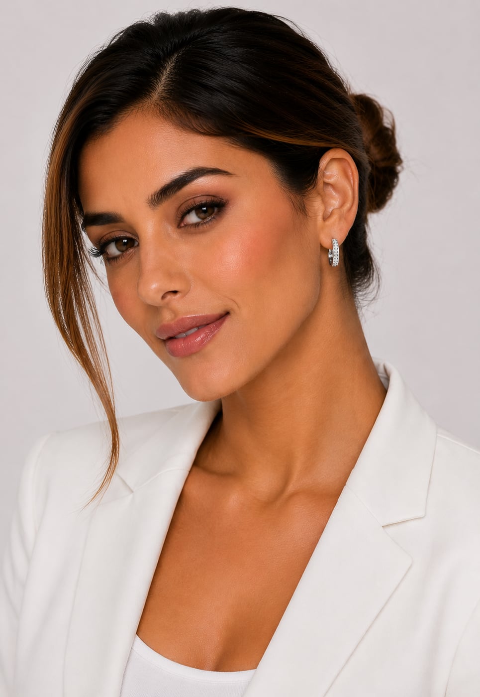 Mulher usando a argola cravejada com blazer branco em produção social